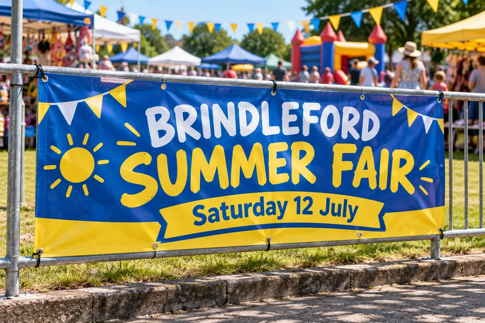Printed PVC banner with eyelets cable-tied to railings at a school summer fair